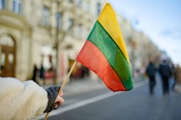 Lithuanian flag during celebration of Restoration of the State Day in Vilnius. Tricolor Lithuanian flag on a public holiday.