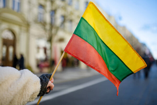 Lithuanian flag during celebration of Restoration of the State Day in Vilnius. Tricolor Lithuanian flag on a public holiday.