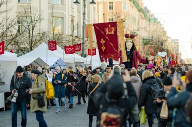 VILNIUS, LITHUANIA - 4 Mart 2024: Kaziuko muge veya Kaziukas, geleneksel Paskalya pazarı sırasında mizahi geçit törenine katılan neşeli insanlar, her Mart ayında Old Town sokaklarında el sanatları fuarı düzenleniyor.
