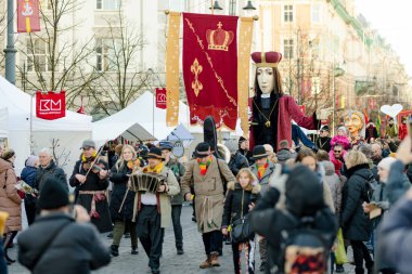 VILNIUS, LITHUANIA - 4 Mart 2024: Kaziuko muge veya Kaziukas, geleneksel Paskalya pazarı sırasında mizahi geçit törenine katılan neşeli insanlar, her Mart ayında Old Town sokaklarında el sanatları fuarı düzenleniyor.