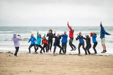 DİNGLE, IRELAND - 19 Mayıs 2023: Inch plajında bir grup turist, muhteşem kum ve kum tepeleri, Dingle Yarımadası, İrlanda 'da bulunan sörf, yüzme ve balıkçılık ile ünlüdür.