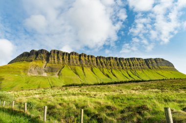 Benbulbin, nam-ı diğer Benbulben ya da Ben Bulben, simgesel simge, büyük düz tepeli nunatak kaya oluşumu. Wild Atlantic Way, County Sligo, İrlanda 'daki muhteşem kostüm sürüş rotası.