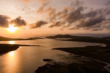 Kerry Çemberi boyunca Derreen Nehri 'nin hava gün batımı manzarası. Gün batımında Iveragh Yarımadası 'nın engebeli kıyıları, Kerry ilçesi, İrlanda.