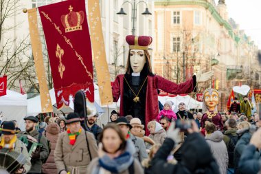 VILNIUS, LITHUANIA - 4 Mart 2024: Kaziuko muge veya Kaziukas, geleneksel Paskalya pazarı sırasında mizahi geçit törenine katılan neşeli insanlar, her Mart ayında Old Town sokaklarında el sanatları fuarı düzenleniyor.