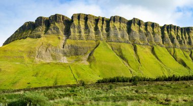 Benbulbin, nam-ı diğer Benbulben ya da Ben Bulben, simgesel simge, büyük düz tepeli nunatak kaya oluşumu. Wild Atlantic Way, County Sligo, İrlanda 'daki muhteşem kostüm sürüş rotası.