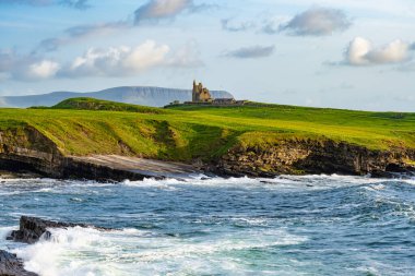 Mullaghmore Head 'in pitoresk manzarasında ünlü Classiebawn Kalesi. Sahile vuran büyük dalgalarla muhteşem bir gün batımı manzarası. Wild Atlantic Way, Co. Sligo, İrlanda 'nın imza noktası