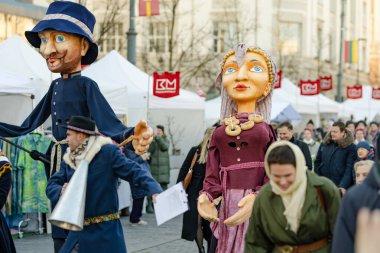 VILNIUS, LITHUANIA - 4 Mart 2024: Kaziuko muge veya Kaziukas, geleneksel Paskalya pazarı sırasında mizahi geçit törenine katılan neşeli insanlar, her Mart ayında Old Town sokaklarında el sanatları fuarı düzenleniyor.