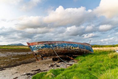 Eski tekne Kerry güzergahı Ring boyunca küçük bir plajda sol. Gün batımında Iveragh Yarımadası'nda Engebeli sahil, County Kerry, İrlanda.