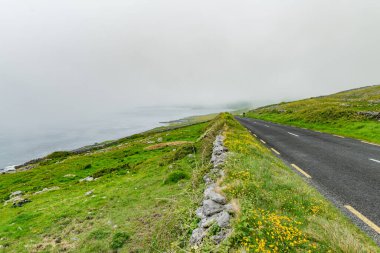 İrlanda 'nın Clare ilçesinin Burren bölgesinde muhteşem sisli bir manzara. Burren Ulusal Parkı 'nda karst kireç taşına maruz kalmış. Sert İrlanda doğası.