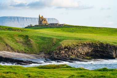 Famous Classiebawn Castle in picturesque landscape of Mullaghmore Head. Spectacular sunset view with huge waves rolling ashore. Signature point of Wild Atlantic Way, Co. Sligo, Ireland clipart