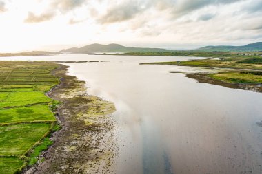 Kerry Çemberi boyunca Derreen Nehri 'nin hava gün batımı manzarası. Gün batımında Iveragh Yarımadası 'nın engebeli kıyıları, Kerry ilçesi, İrlanda.