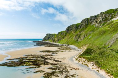 Five Finger Strand, one of the most famous beaches in Inishowen known for its pristine sand and surrounding rocky coastline with some of the highest sand dunes in Europe, county Donegal, Ireland. clipart