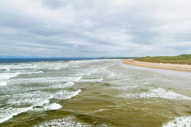Muhteşem Tullan Strand, Donegal'ın ünlü sörf plajlarından biri, Sligo-Leitrim Dağları tarafından sağlanan doğal bir arka damla ile çerçeveli. County Donegal, İrlanda geniş düz kumlu plaj.