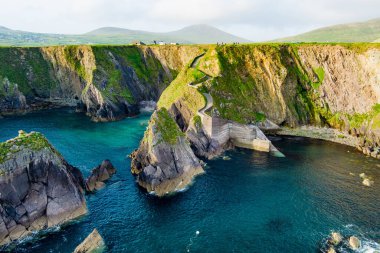 Dunquin veya Dun Chaoin İskelesi, İrlanda 'nın koyun otobanı. İskeleye, okyanus kıyılarına, uçurumlara uzanan dar patikaların havadan görünüşü. Slea Head Drive ve Wild Atlantic Yolu 'nda popüler ikonik konum.