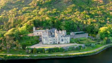 Gün batımında Kylemore Manastırı 'nda. Kylemore Kalesi 'nde kurulan bir Benedikt manastırı. Connemara güneşli yaz akşamı hava manzarası. İrlanda 'nın Galway ilçesinin ünlü turistik merkezi..