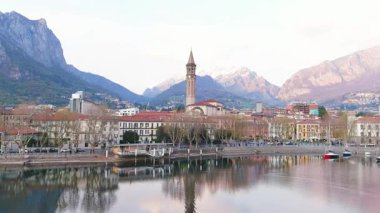 Lecco şehri ve tatil köyünün hava güzelliğinde gün batımı manzarası. Lecco kasabasının ünlü Como Gölü ve Bergamo Alpleri arasında bulunan Picturesque rıhtımı. İtalya 'da tatil beldesi.