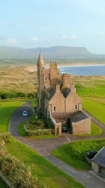 Mullaghmore Head 'in muhteşem hava yörüngesi gün batımı görüntüsü. Büyük dalgalar kıyıya vuruyor. Muhteşem Classiebawn Kalesi 'nin dehşet verici manzarası. Vahşi Atlantik Yolu 'nun imza noktası, Sligo, İrlanda.