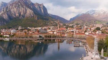 Lecco şehri ve tatil köyünün hava güzelliğinde gün batımı manzarası. Lecco kasabasının ünlü Como Gölü ve Bergamo Alpleri arasında bulunan Picturesque rıhtımı. İtalya 'da tatil beldesi.
