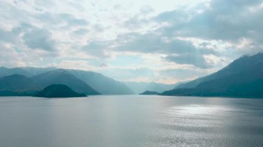 Lago di Como. Varenna civarındaki Como Gölü 'nün havadan panoramik manzarası. Temiz hava, ufuktaki bulutlar, dağ silüeti, resimli balıkçı köyleri. Ünlü turist bölgesi. İtalya