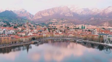 Lecco şehri ve tatil köyünün hava güzelliğinde gün batımı manzarası. Lecco kasabasının ünlü Como Gölü ve Bergamo Alpleri arasında bulunan Picturesque rıhtımı. İtalya 'da tatil beldesi.