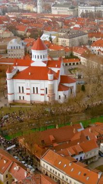 Yüzlerce insanın kutlamaların ve Vilnius 'ta Aziz Patrick Günü' nün keyfini çıkardığı dikey hava manzarası. Vilnele Nehri, Ireland Günü 'nün koruyucu azizi olsun diye yeşile boyandı..