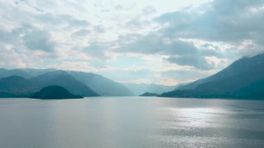 Lago di Como. Varenna civarındaki Como Gölü 'nün havadan panoramik manzarası. Temiz hava, ufuktaki bulutlar, dağ silüeti, resimli balıkçı köyleri. Ünlü turist bölgesi. İtalya