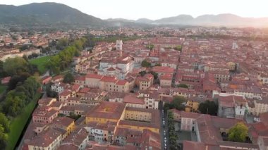 El değmemiş Rönesans dönemi şehir duvarları ve iyi korunmuş tarihi merkeziyle ünlü Lucca şehrinin hava günbatımı manzarası. Lucca ili, Toskana, İtalya.