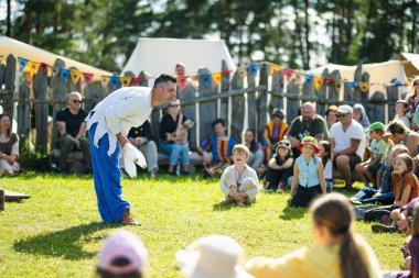 KERNAVE, LITHUANIA - 5 Temmuz 2024: Kernave 'de düzenlenen yıllık Deneysel Arkeoloji Festivali sırasında ortaçağ kostümleri giyen tarihi canlandırma eylemcileri. Ortaçağ kasaba ruhunu yeniden yaratıyor..