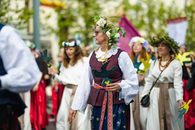 VILNIUS, LITHUANIA - 7 Temmuz 2024: Ulusal Litvanya Şarkı ve Dans Festivali geçit töreni sırasında geleneksel giysiler içinde neşeli insanlar grubu.