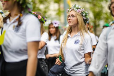 VILNIUS, LITHUANIA - 7 Temmuz 2024: Ulusal Litvanya Şarkı ve Dans Festivali geçit töreni sırasında geleneksel giysiler içinde neşeli insanlar grubu.