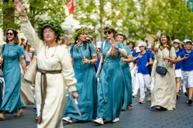 VILNIUS, LITHUANIA - 7 Temmuz 2024: Ulusal Litvanya Şarkı ve Dans Festivali geçit töreni sırasında geleneksel giysiler içinde neşeli insanlar grubu.