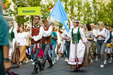 VILNIUS, LITHUANIA - 7 Temmuz 2024: Ulusal Litvanya Şarkı ve Dans Festivali geçit töreni sırasında geleneksel giysiler içinde neşeli insanlar grubu.