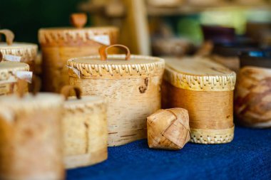 Geleneksel işçilik ve kültür mirasını kutlamak amacıyla, arkeolojik bir ortaçağ festivalinde ahşap raflarda, karmaşık oymalı huş ağacı kabuğu kabukları sergileniyor..