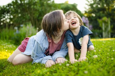 Şirin ablasının küçük kardeşiyle kucaklaşması. Sevimli genç kız küçük kardeşine sarılıyor. Doğayı keşfeden çocuklar. Kardeşler iyi anlaşıyor..