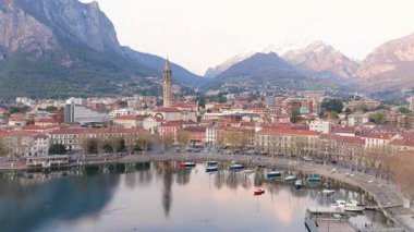 Lecco şehri ve tatil köyünün hava güzelliğinde gün batımı manzarası. Lecco kasabasının ünlü Como Gölü ve Bergamo Alpleri arasında bulunan Picturesque rıhtımı. İtalya 'da tatil beldesi.