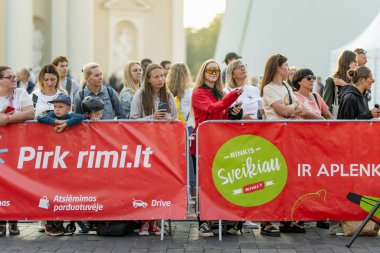 VILNIUS, LITHUANIA - 8 Eylül 2024: Vilnius Maratonu 'nun engelleri arkasında toplanan taraftarlar, gururla, umutla ve yüreklendirici bir cesaretle koşuculara tezahürat ediyorlar.