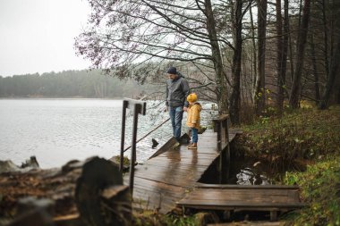 Litvanya 'daki Balzis Gölü rıhtımında, sakin bir orman ve sakin bir suyla çevrili baba ve çocuk arasında çok iç açıcı bir an..