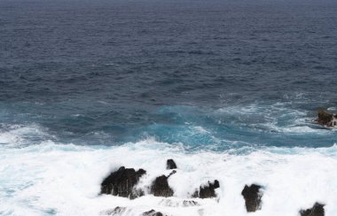 Okyanustaki kayalıklarda deniz manzarası dalgaları