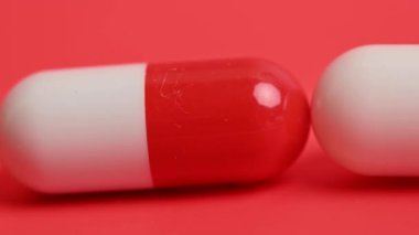 tıbbi kapsüller kırmızı arkaplanda yakın plan