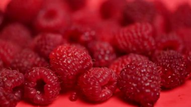 Kırmızı arka planda ahududu meyveleri.