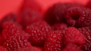 Kırmızı arka planda ahududu meyveleri.