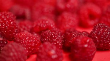 Kırmızı arka planda ahududu meyveleri.