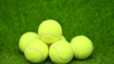 Yeşil çimenlerin üzerinde tenis topları yakın.