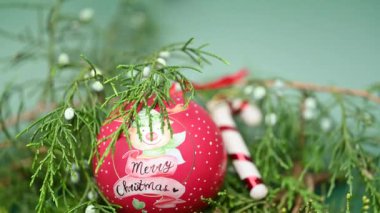 Yeşil arka planda noel oyuncağı olan thuja şubesi