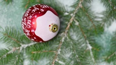 Yeşil arka planda Noel oyuncağı ve karlı ladin dalları