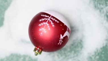 Yeşil arka planda Noel oyuncağı ve karlı ladin dalları