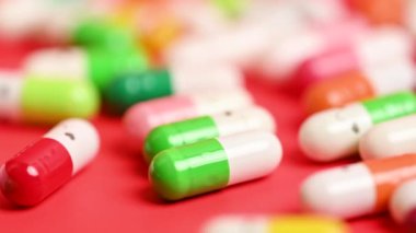 tıbbi kapsüller kırmızı arkaplanda yakın plan