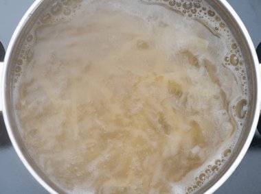 Bir tencere makarna kaynıyor.