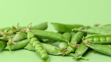 açık yeşil arkaplanda yeşil bezelye kabukları