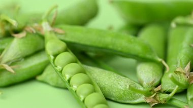 açık yeşil arkaplanda yeşil bezelye kabukları